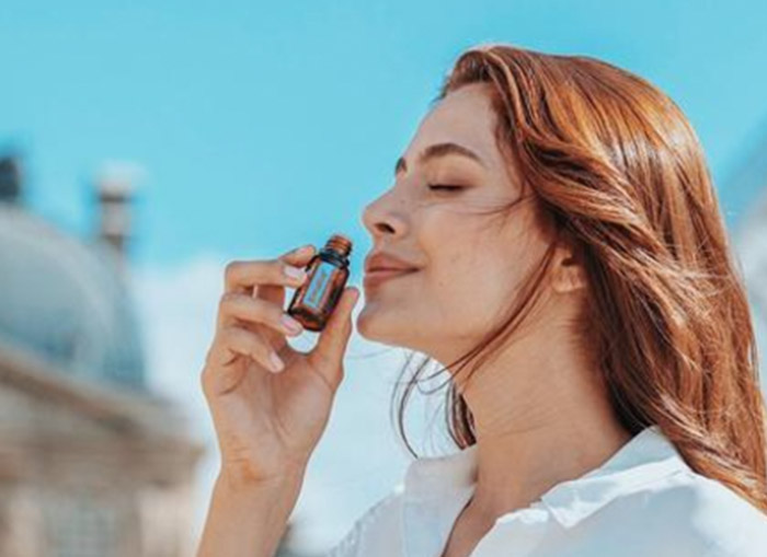 A woman smelling doTERRA Breathe essential oil