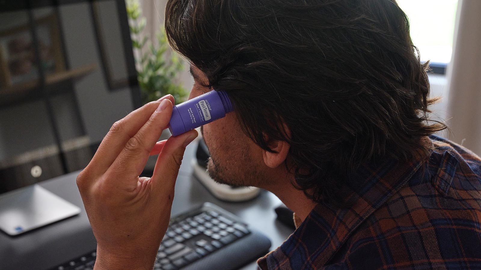 A man applying the PastTense stick to his temple