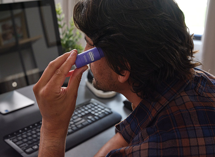 A man applying the PastTense stick to his temple