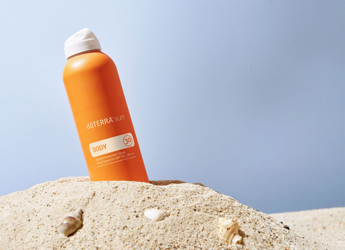 Sunscreen Spray partially buried in sand