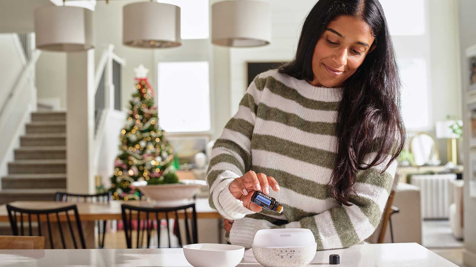Woman pouring peppermint into diffuser