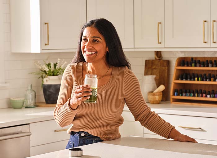 A woman standing holding a glass of VMG