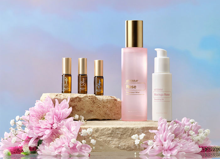 Rose mist, rose oil, beautiful touch oil, shine touch oil, and whisper touch oil atop a stone
