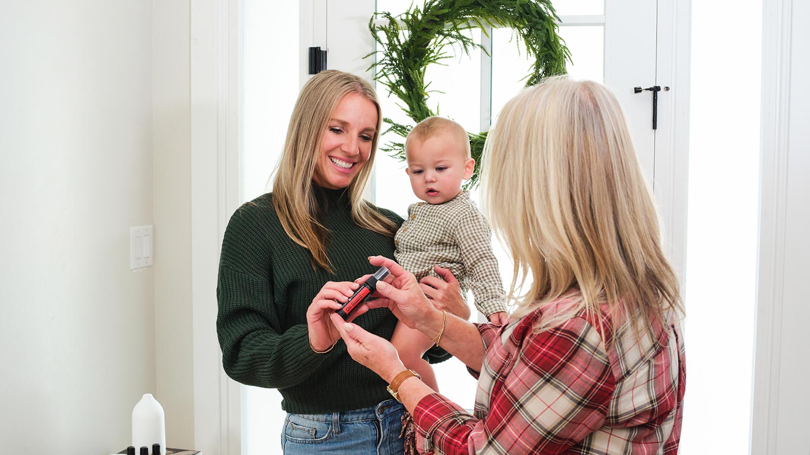 Two woman meeting in entryway, one holding a baby