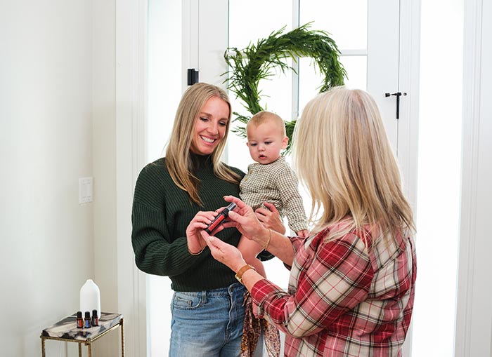 Two woman meeting in entryway, one holding a baby