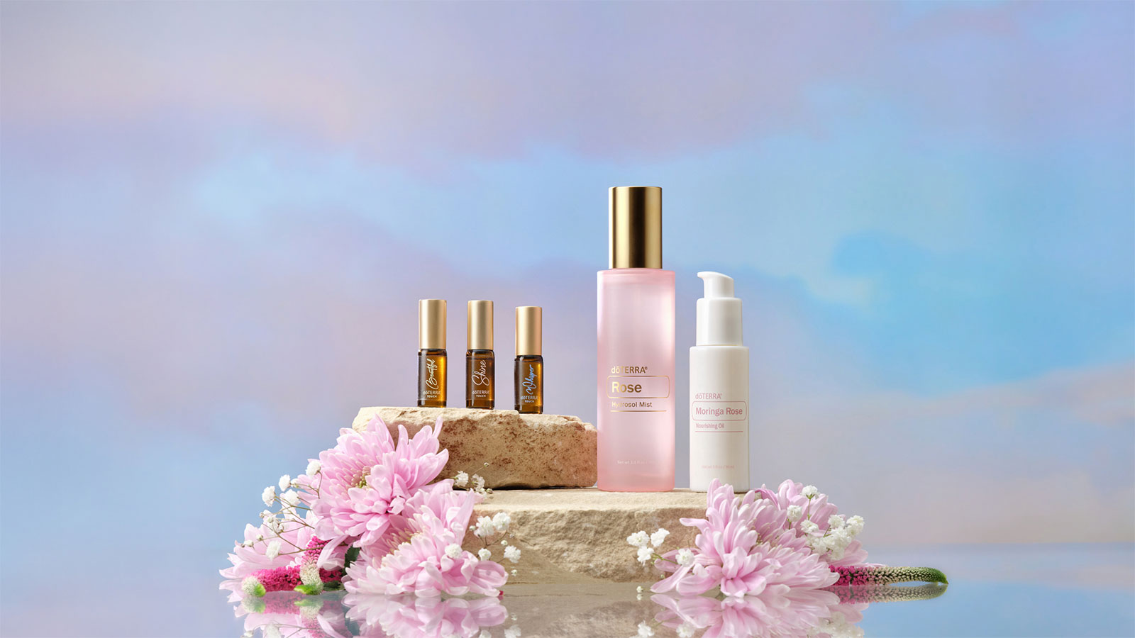 Rose mist, rose oil, beautiful touch oil, shine touch oil, and whisper touch oil atop a stone