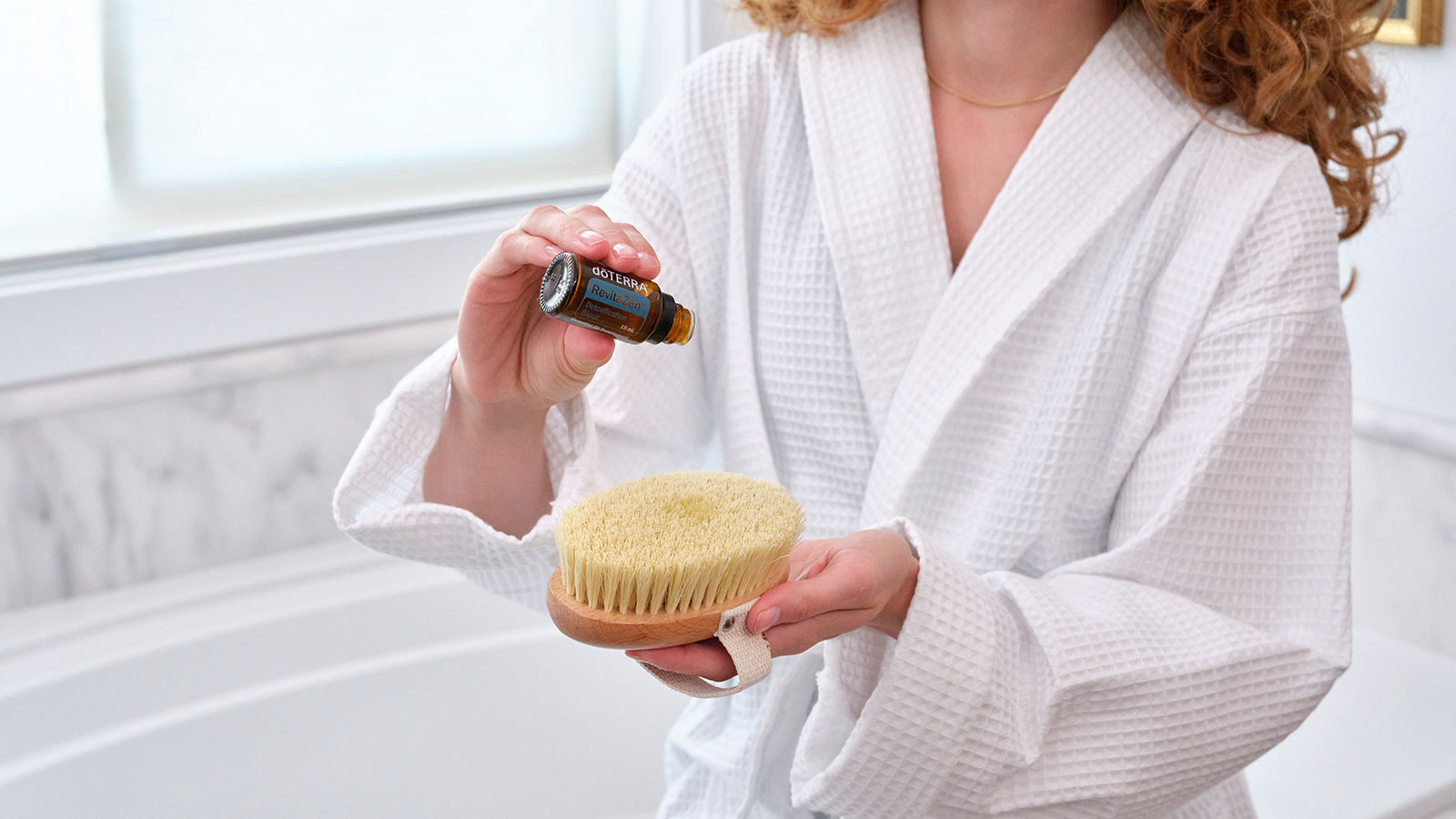A woman putting RevitaZen on a shower scrub