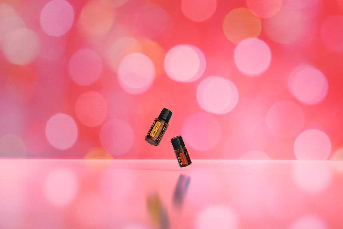 Citrus bliss and cinnamon bark oil bottles with pink background.