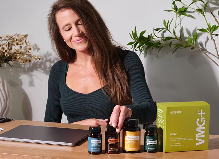 A woman in front of a table that has various doTERRA products on it
