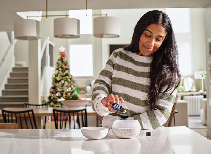 Woman pouring peppermint into diffuser