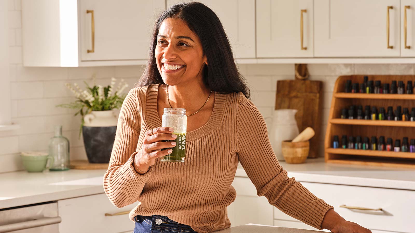 A woman standing holding a glass of VMG