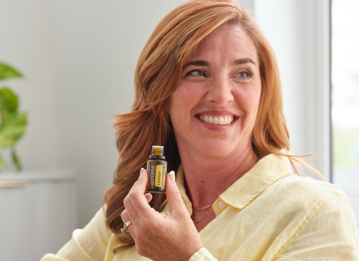 Woman Smiling with doTerra oil bottle.