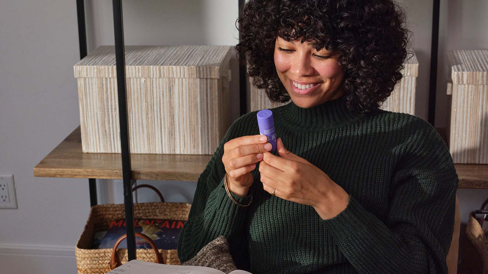 A woman sitting in a chair looking at the PastTense stick
