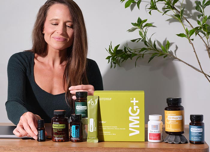 A woman behind a table with various doTERRA products on it