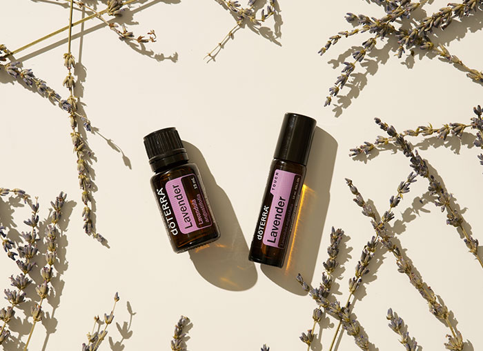 Two bottles of doTERRA essential oil surrounded by lavender plants
