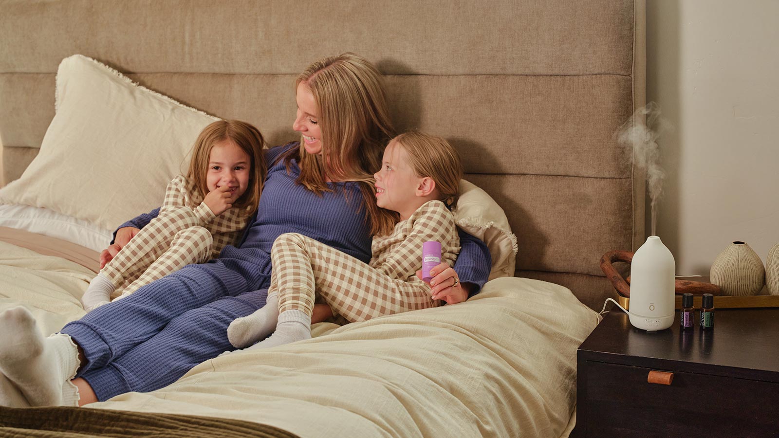 Woman laying in bed with her two children