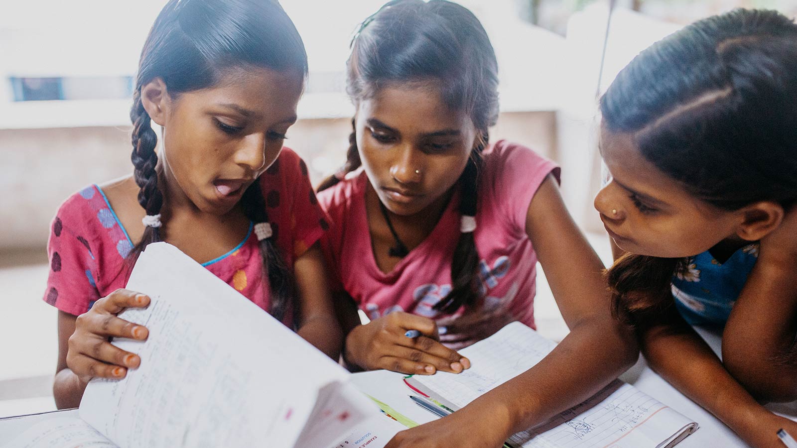 Young girl students at the Bihar campus stand together smiling, wearing school uniforms, made possible through donations from doTERRA Healing Hands.